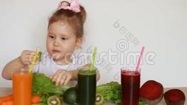 可爱的<strong>宝宝</strong>吃绿叶莴苣。 小女孩喝<strong>蔬菜</strong>冰沙-胡萝卜，甜菜和绿色。