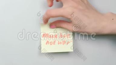 特写女人`手贴黄色贴纸纸，用文字使爱情不战。