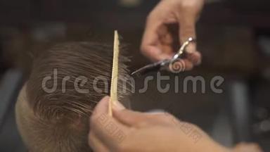 儿童美发沙龙理发师用理发剪剪头发.. 儿童用剪刀剪发，并在