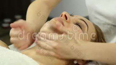 美丽的女人在水疗中心做面部按摩。 美容院面部皮肤护理。 4K