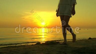 一个年轻的女人在夕阳的背景下<strong>赤脚</strong>走在沙滩上。 3.这女孩<strong>走路</strong>很慢