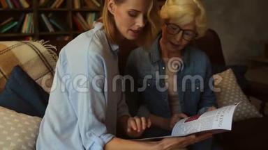 积极向上的老妇人和她的女儿在看时装杂志