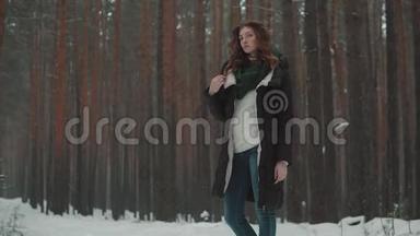 冬天森林里一个红头发的女孩的肖像。 冬天降雪。 慢动作