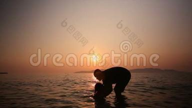 4太阳落山的气氛、谷物和黑暗处理，父亲抱着女儿在海里的K形剪影