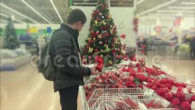 成年人正在超市为<strong>圣诞</strong>树挑选装饰品
