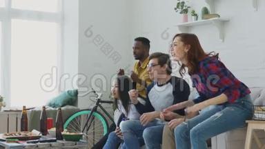 快乐的年轻朋友在电视上观看<strong>体育比赛</strong>，在家庆祝最喜爱的球队胜利