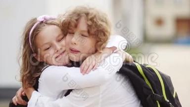 暑假过后，学童拥抱。 再去学校。 知识日。 可爱的孩子们，男孩和女孩拥抱