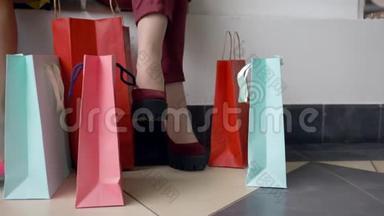 购物日，时尚女孩的脚与许多彩色购物袋在折扣和销售季节