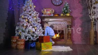 一个男孩把五颜六色的包裹礼物放在圣诞树<strong>下</strong>。