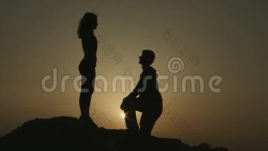 黎明时分，男人在山上向女人求婚。 相爱的幸福夫妻