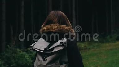 镜头跟随年轻女孩徒步旅行者走在户外的背景森林景观与<strong>高大</strong>的<strong>树木</strong>在山上。
