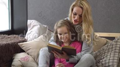 母女俩<strong>拥</strong>抱着<strong>坐</strong>在床上看书
