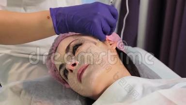 那个女人正在做皮肤增光的手术。 病人特写`脸。 电器真皮。