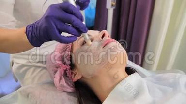 那个女人正在做皮肤增光的手术。 病人特写`脸。 电器真皮。 东方东方