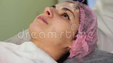 这位年轻女子在手术过程中`了脸。 创新的美容程序。 医疗程序复兴。