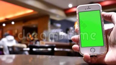 绿色屏幕手机与模糊的人吃食物和聊天的运动