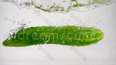 绿色的新鲜黄瓜在白色的背景下落入水中