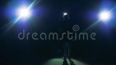 足球足球足球运动员剪影。 职业足球运动员在黑暗中与球一起练习。