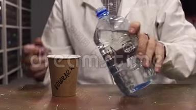 穿着白色实验服的人把水从塑料瓶倒入棕色纸杯