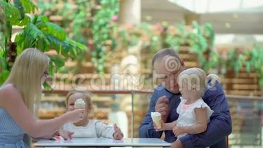 小女孩在大购物中心吃<strong>冰淇淋</strong>和一个喇叭。 家人在商场里吃<strong>冰淇淋</strong>。 家庭幸福。 可爱