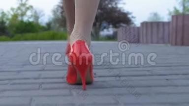 穿红色高跟鞋的女士双脚在街上行走，有攻击的危险