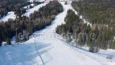 滑雪场背景下滑雪坡的俯视图。 录像。 美丽的滑雪场景观和茂密的云杉林