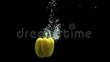黄铃椒<strong>落入水中</strong>，大量气泡和水溅出黑色背景