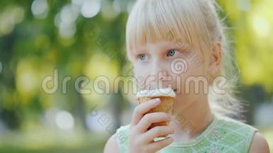 体贴的女孩6岁正在公园里吃冰淇淋。 暑假和假期