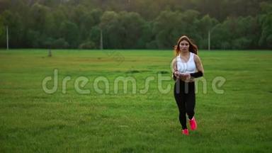 女孩穿着白色上衣和黑色紧身衣跑过田野。