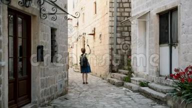 年轻快乐的女人在黑山旅行，看着佩拉斯的地标，时髦的女孩带着地图在市中心做了一个