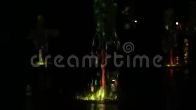 彩色的水夜喷泉随着灯光<strong>舞动</strong>，彩色模糊镜头背景，近景，浅景