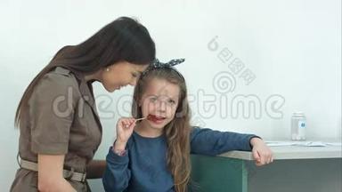 妈妈和她的<strong>小女孩</strong>在<strong>医生</strong>办公室吃棒棒糖`谈话