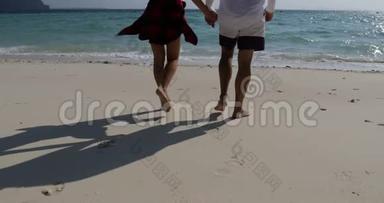一对夫妇在海滩后景，男人和女人快乐的举起手海假日