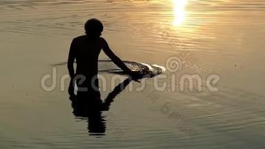 年轻人在河流中开凿，看日落