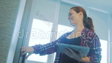 女孩从冰箱里拿食物，看着一台数字平板电脑。 <strong>智能家居</strong>概念女孩慢动作视频。 妇女