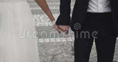 年轻夫妇牵着手，慢吞吞地走在街上。 4k. 高清高清