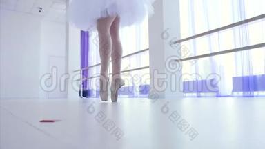 穿着白色芭蕾舞裙的芭蕾舞演员在芭蕾舞课上跳舞。