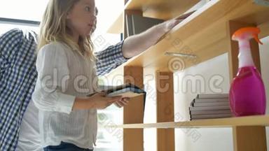 可爱的小女孩在打扫卫生时整理书籍