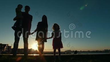 全家人的肖像-父亲、母亲、女儿和小儿子-日落时的轮廓，在天际线前