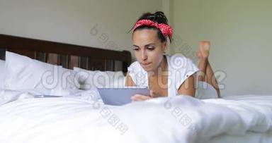 年轻女子用平板电脑美女躺在床上卧室早上<strong>上网聊天</strong>