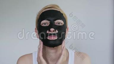 女，40岁，脸上戴着一个恢复青春活力的黑色组织面膜