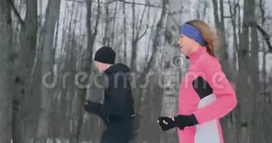 青年男女在冬林晨跑.. 一个穿宽松夹克的女人，一个穿黑色夹克的男人在跑步