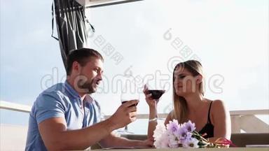 一对年轻夫妇在一家餐馆庆祝他们的结婚纪念日，恋人们喝酒