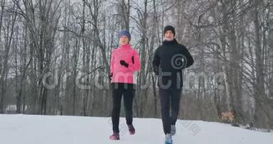 青年男女在冬林晨跑.. 一个穿宽松<strong>夹克</strong>的女人，一个穿<strong>黑色夹克</strong>的男人在跑步