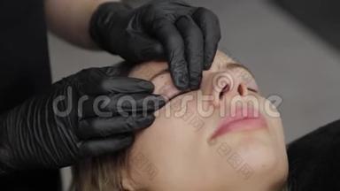 专业美容师在一家美容院胶水硅胶衬里睫毛层。
