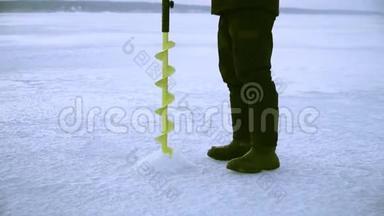 一个渔民在冬天用冰<strong>钻</strong>在结冰的河上<strong>钻洞</strong>
