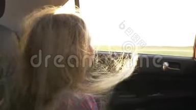 年轻的白种人女孩望着地平线到车窗。 打开车窗，大风吹动她的头发。 关门