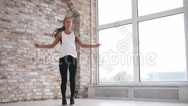 年轻和运动的女人在健身俱乐部里通过跳绳来锻炼肌肉