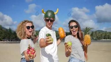 三个年轻的朋友在海滩上疯狂，和异国情调的泰国水果跳舞。 纯素舞蹈。 泰国范甘。 <strong>高清高清</strong>