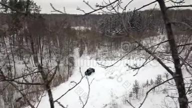 一辆6x6<strong>越野车</strong>的鸟瞰图，它在冬天森林里的雪覆盖的道路上行驶